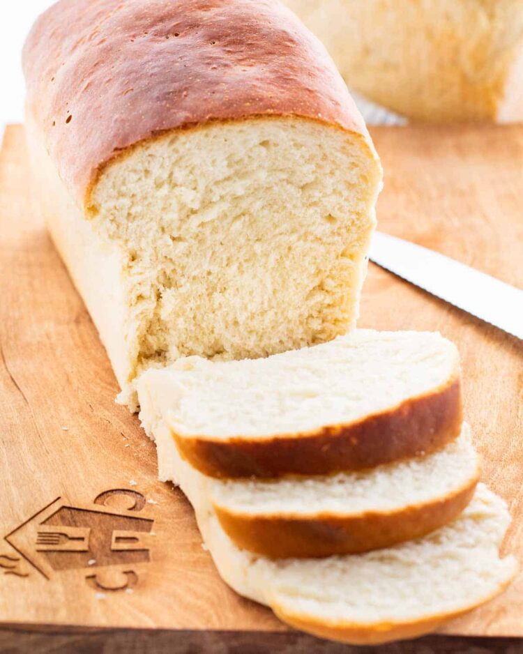 a amish white bread on a cutting board with 3 slices of bread