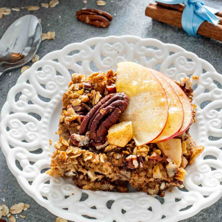 a slice of apple pie baked oatmeal on a white plate.