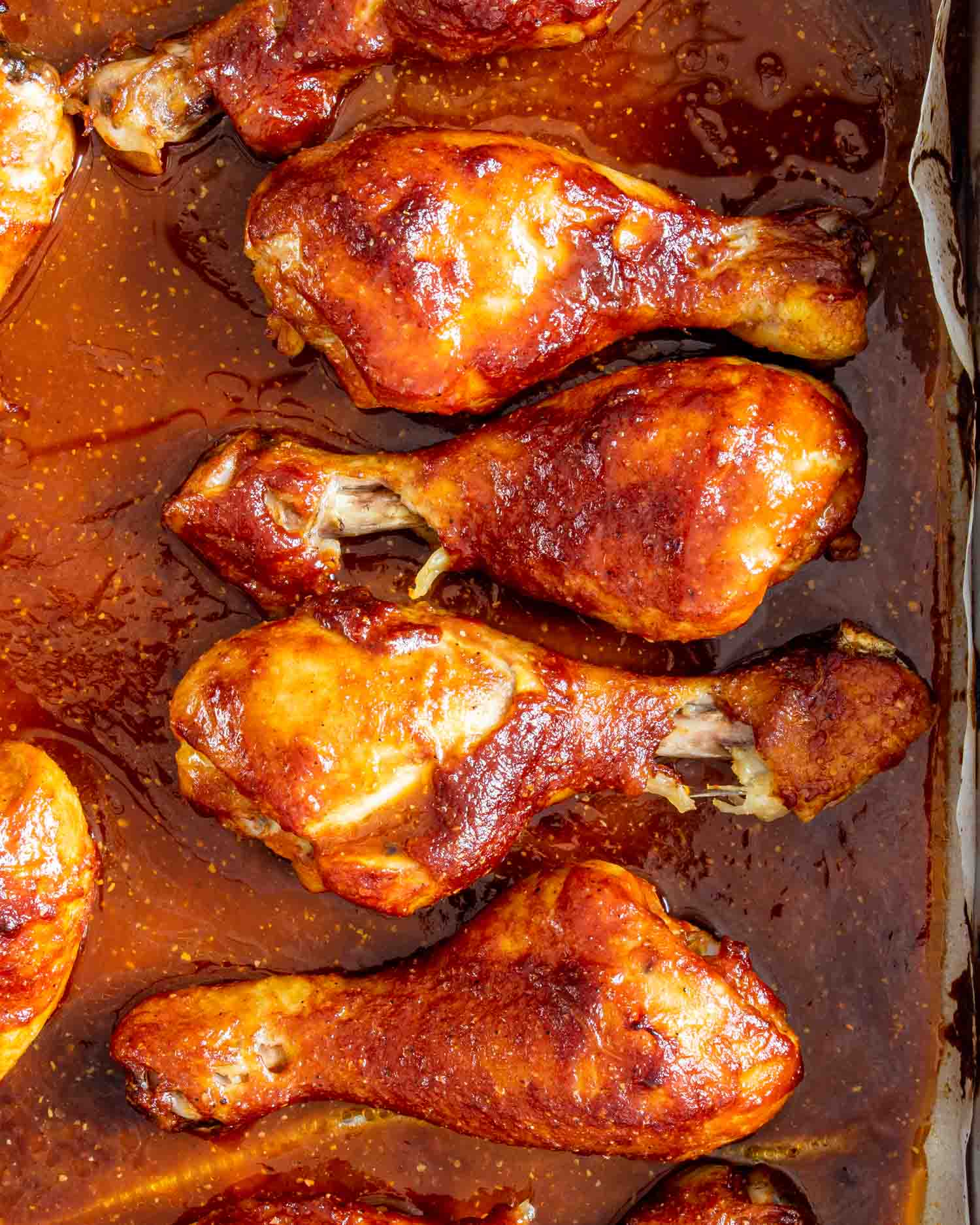 baked bbq chicken drumsticks in a baking dish.