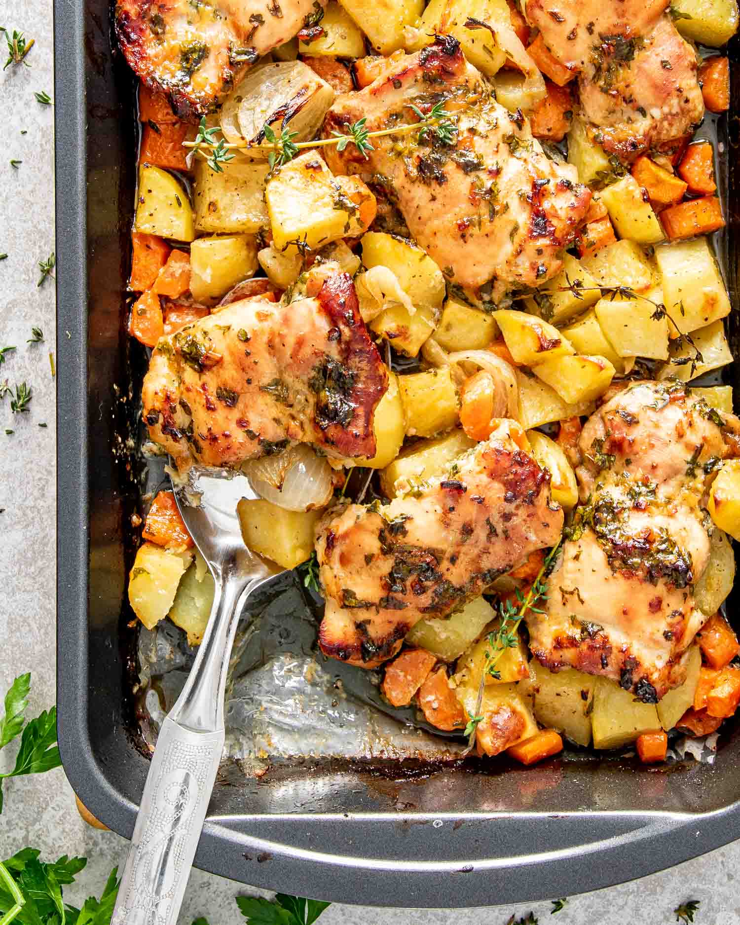 fresh out of the oven baked honey mustard chicken with potatoes in a baking pan.