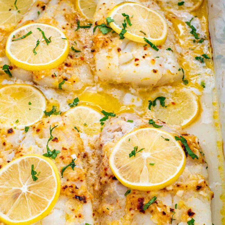 freshly baked lemon butter cod in a white baking pan.
