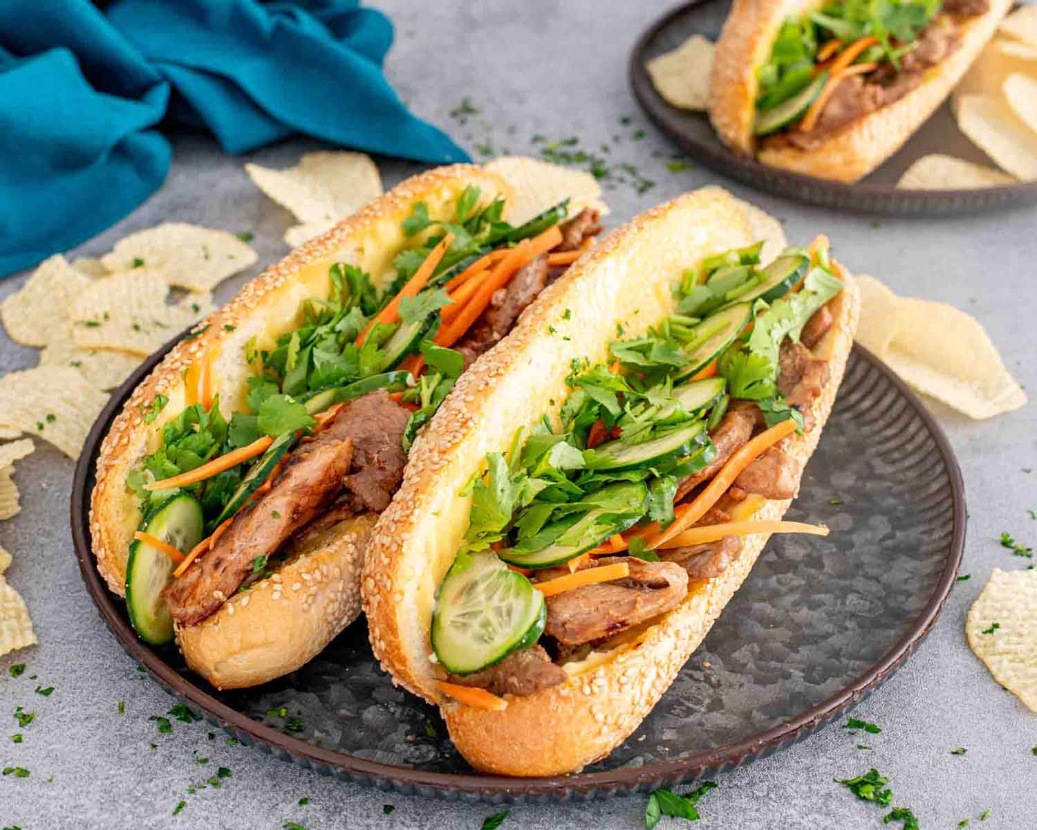2 banh mi sandwiches on a metal plate.