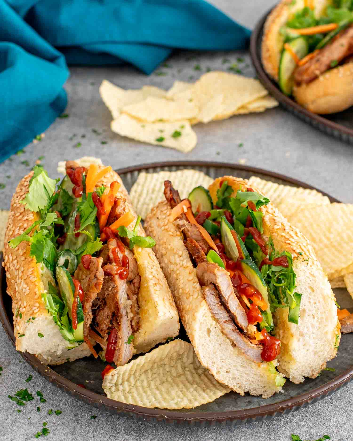 2 banh mi sandwiches on a metal plate.
