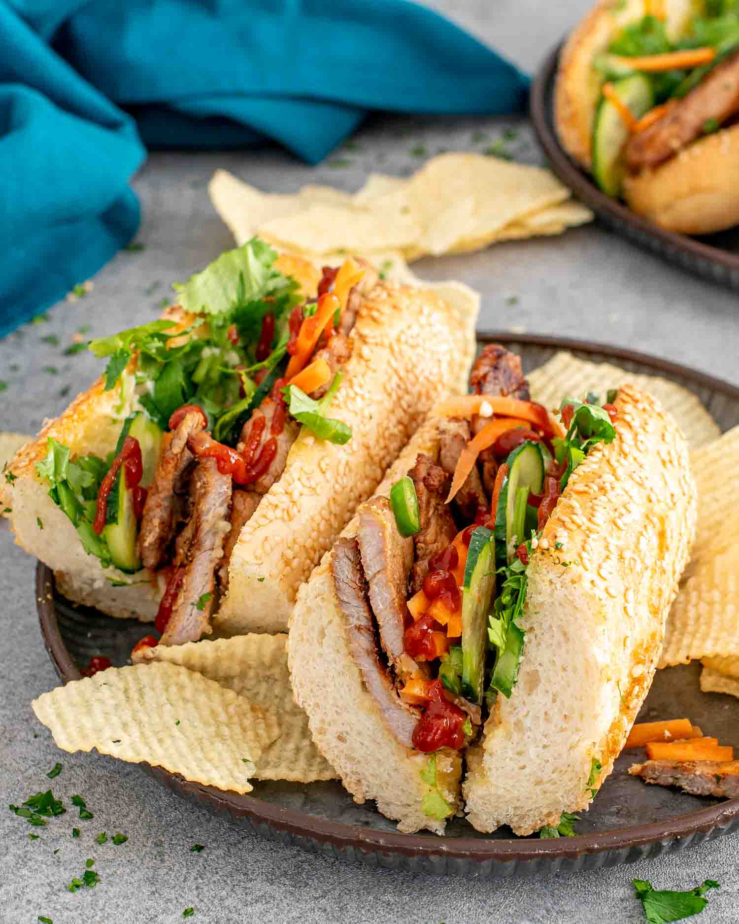 2 banh mi sandwiches on a metal plate.