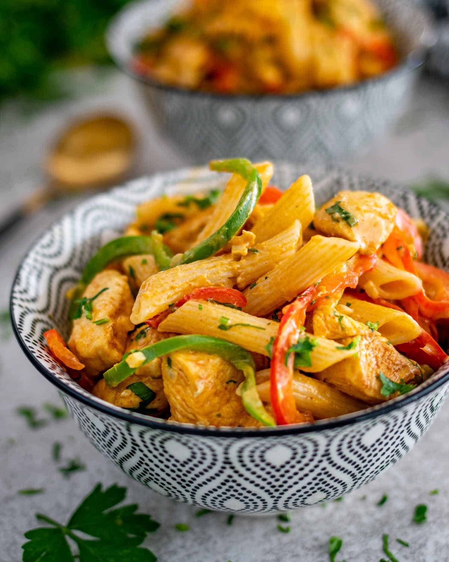 a serving of buffalo chicken pasta in a black and white bowl.