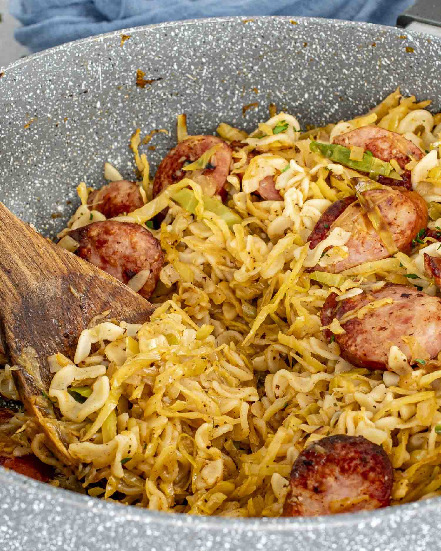 a big skillet with freshly made cabbage and noodles with sausage.