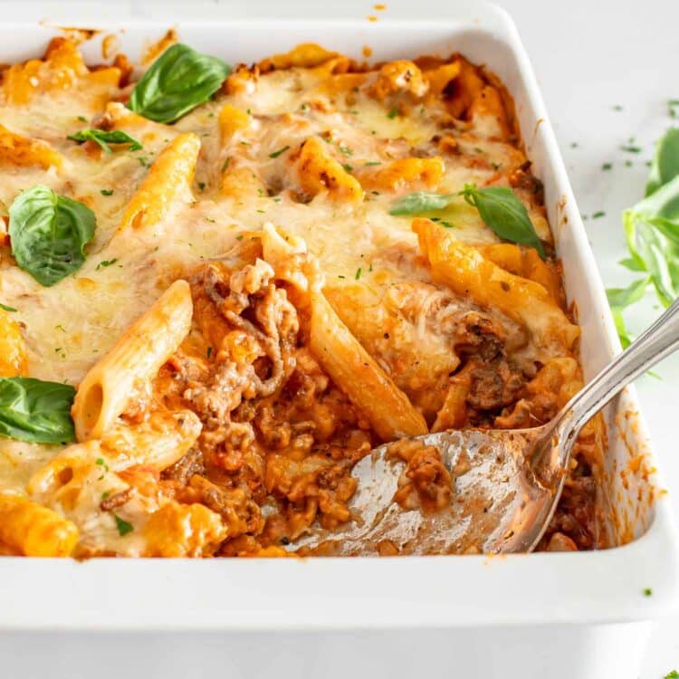 cheesy tomato beef bake in a white casserole dish.