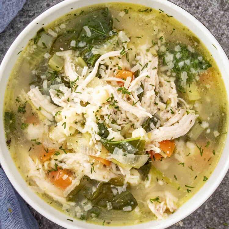 a serving of chicken and leek soup in a bowl garnished with a bit of Parmesan cheese.