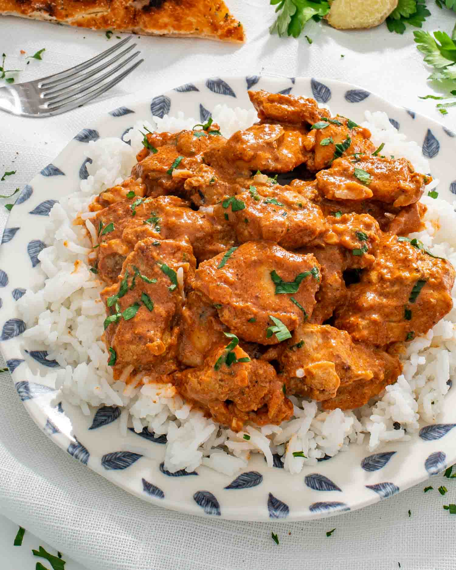 chicken tikka masala over a bed of rice garnished with cilantro.