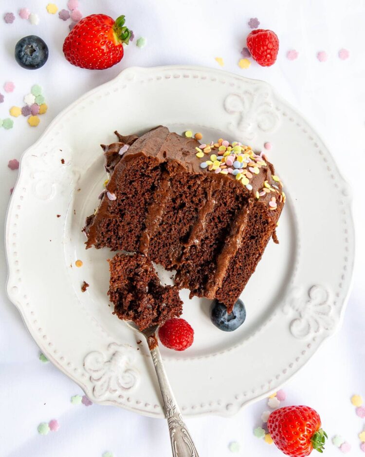 overhead shot of a slice of chocolate cake on a white plate