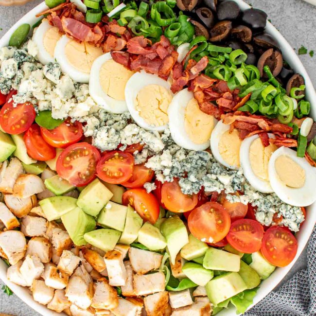 A fresh and colorful Cobb salad arranged beautifully in a bowl.