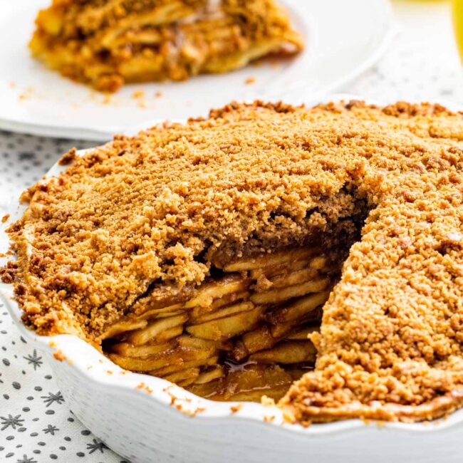 closeup of a dutch apple pie with a slice taken out of it.