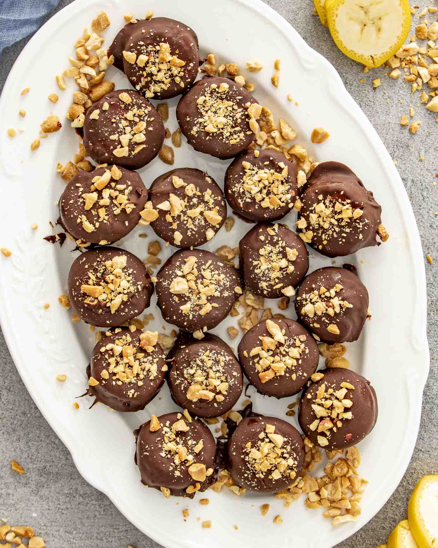 Overhead shot of frozen chocolate banana bites arranged on a platter, dusted with chopped nuts and ready to serve.