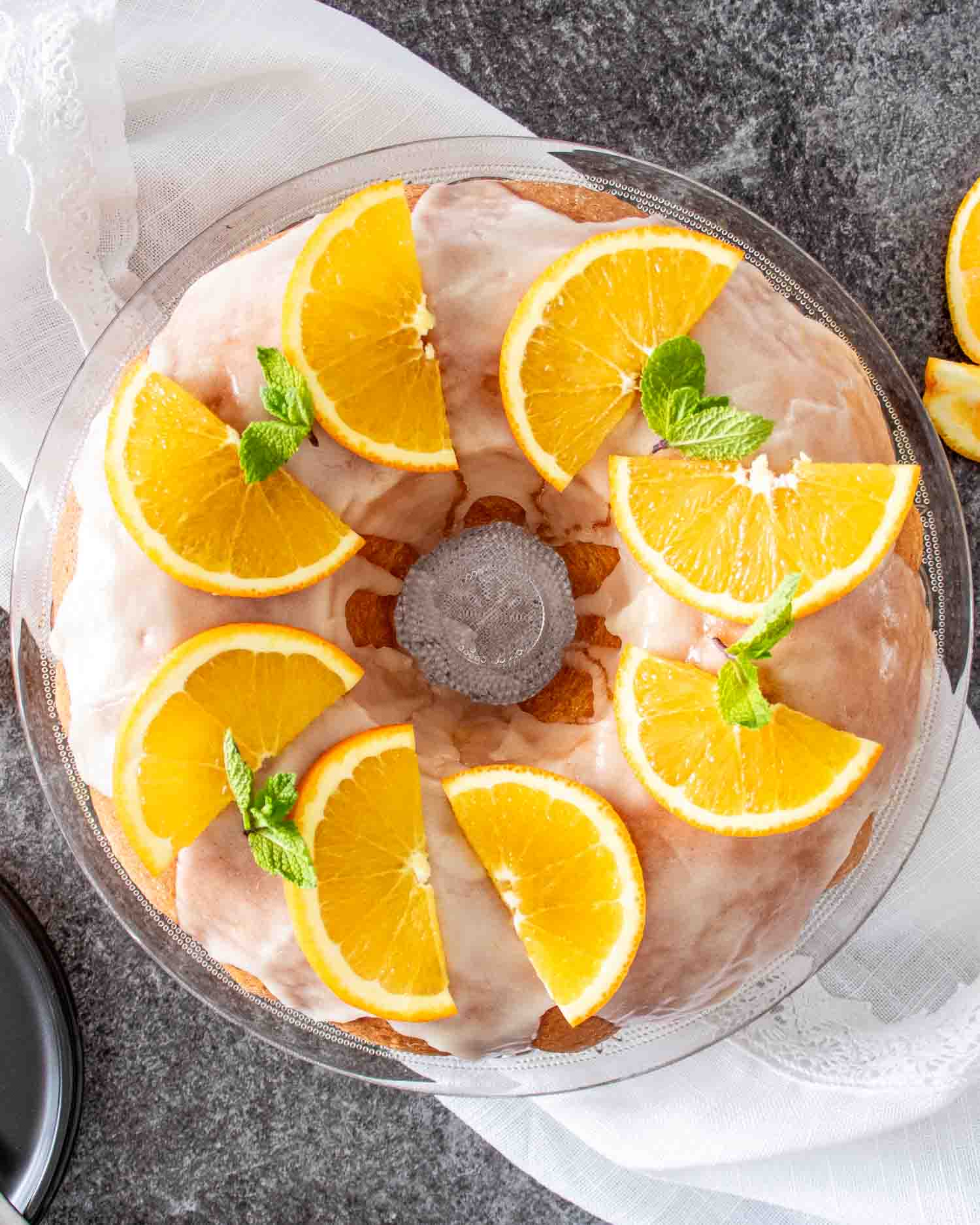 a freshly baked harvey wallbanger cake garnished with orange slices on a cake platter.