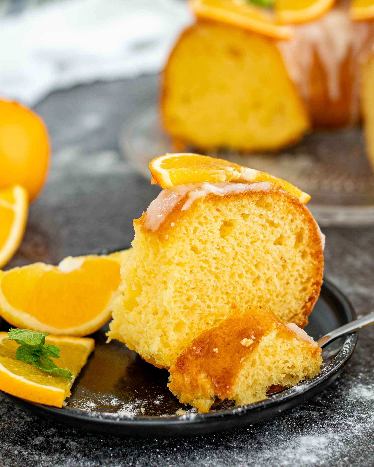 a slice of harvey wallbanger cake on a black plate.
