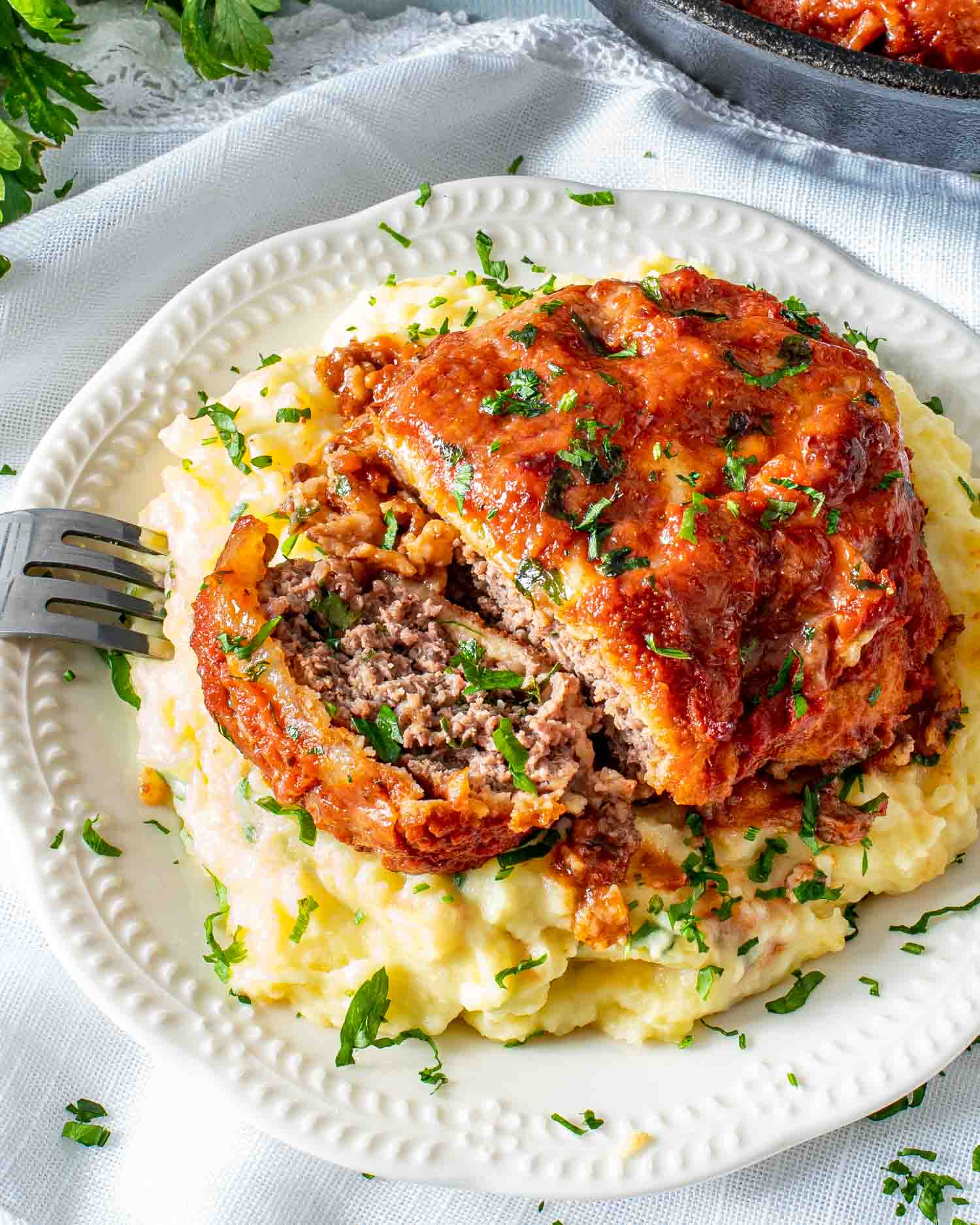 italian hamburger steak over a bed of mashed potatoes.
