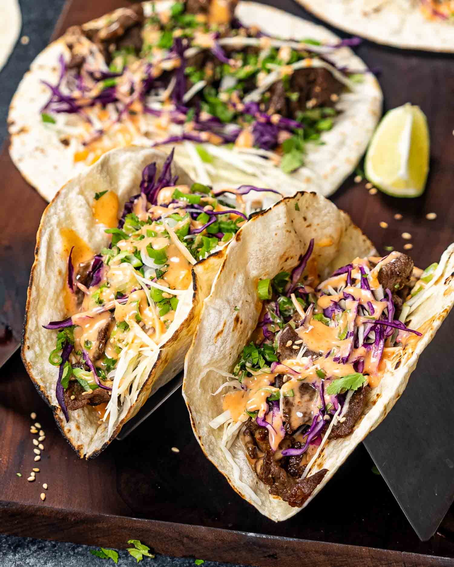 two korean beef tacos on a taco stand.