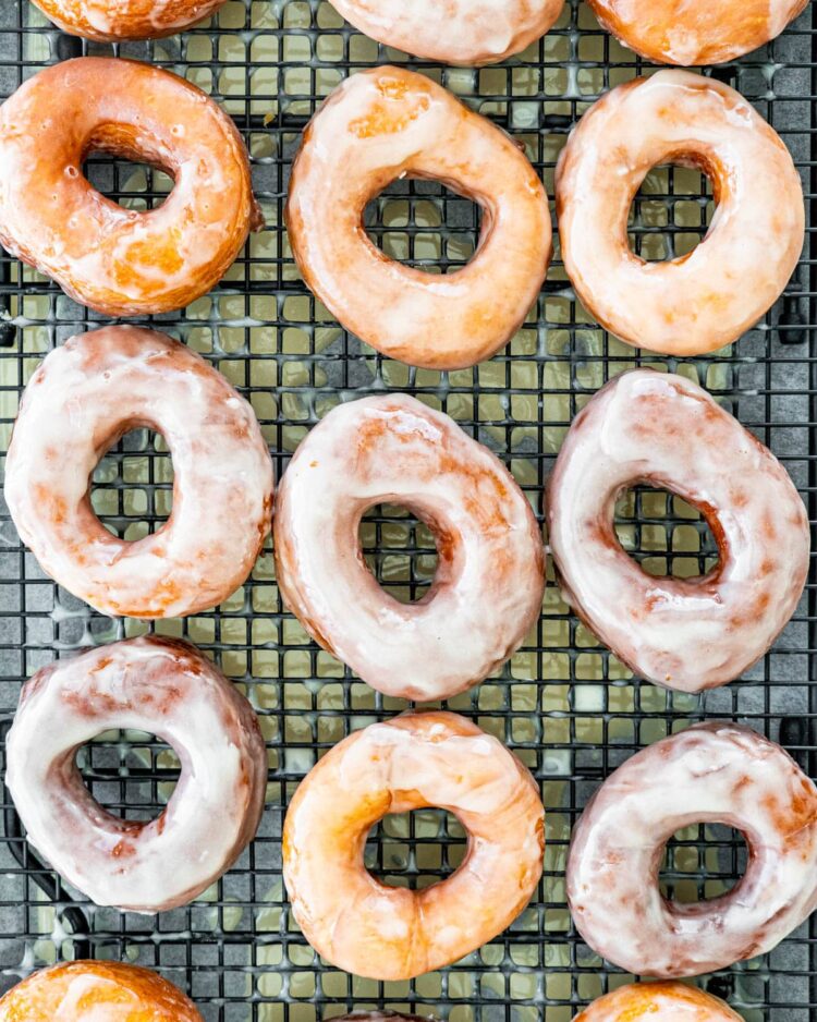 overhead shot of kripsy kreme donuts on a cooling rack
