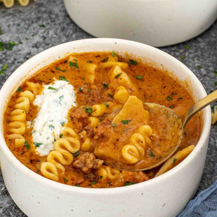 a bowl of lasagna soup with a dollop or ricotta and mozzarella cheese mixture.