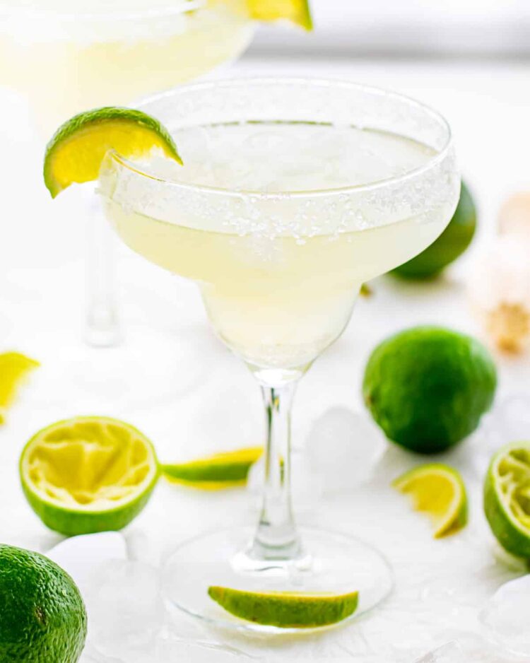 margarita in a rimmed glass with lime wedges