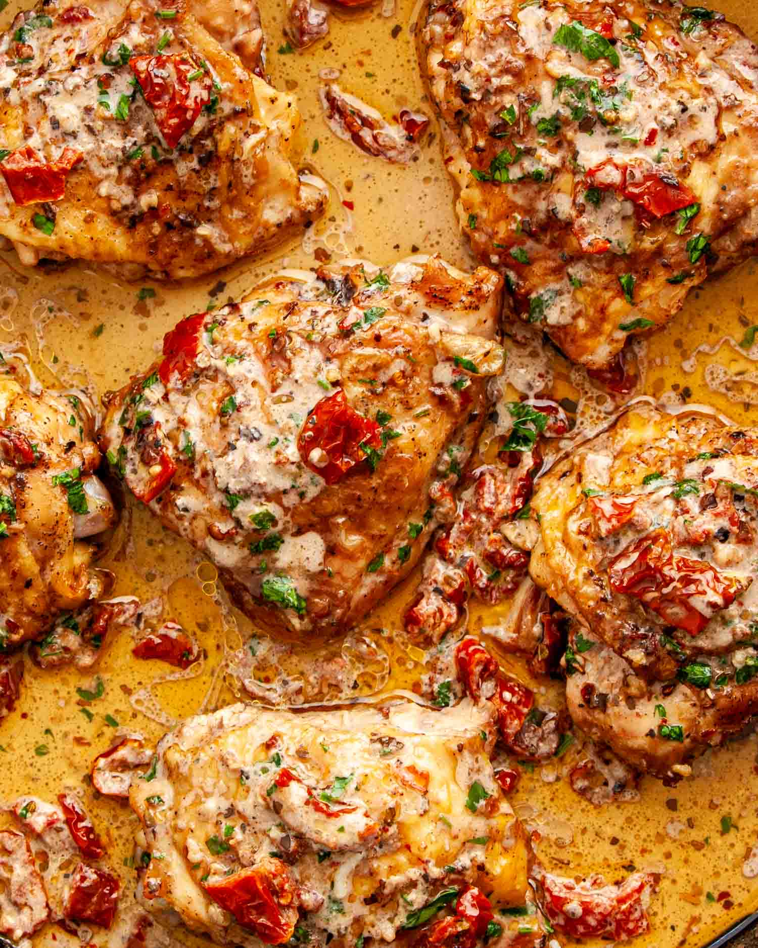 freshly made marry me chicken in a cast iron skillet garnished with parsley.