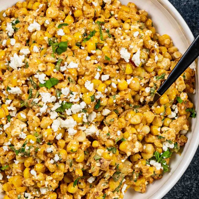 freshly made (mexican street corn salad in a white bowl.