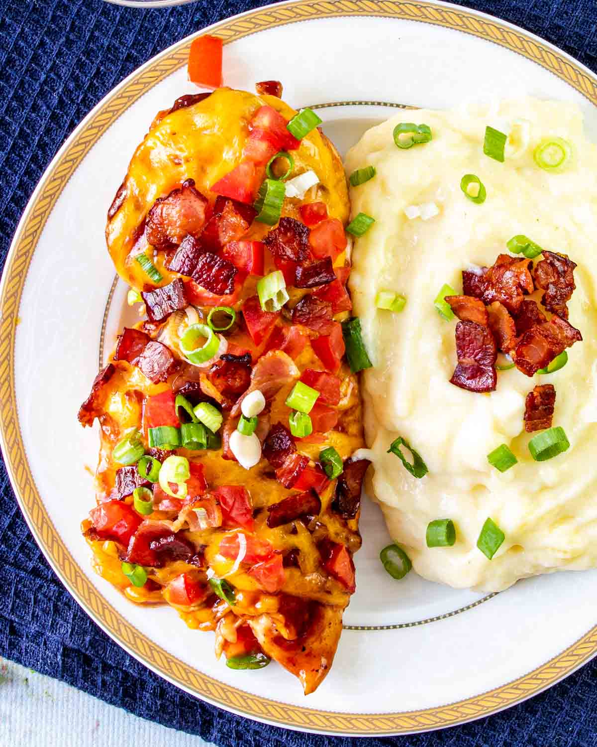 a monterey chicken breast with mashed potatoes on a plate.