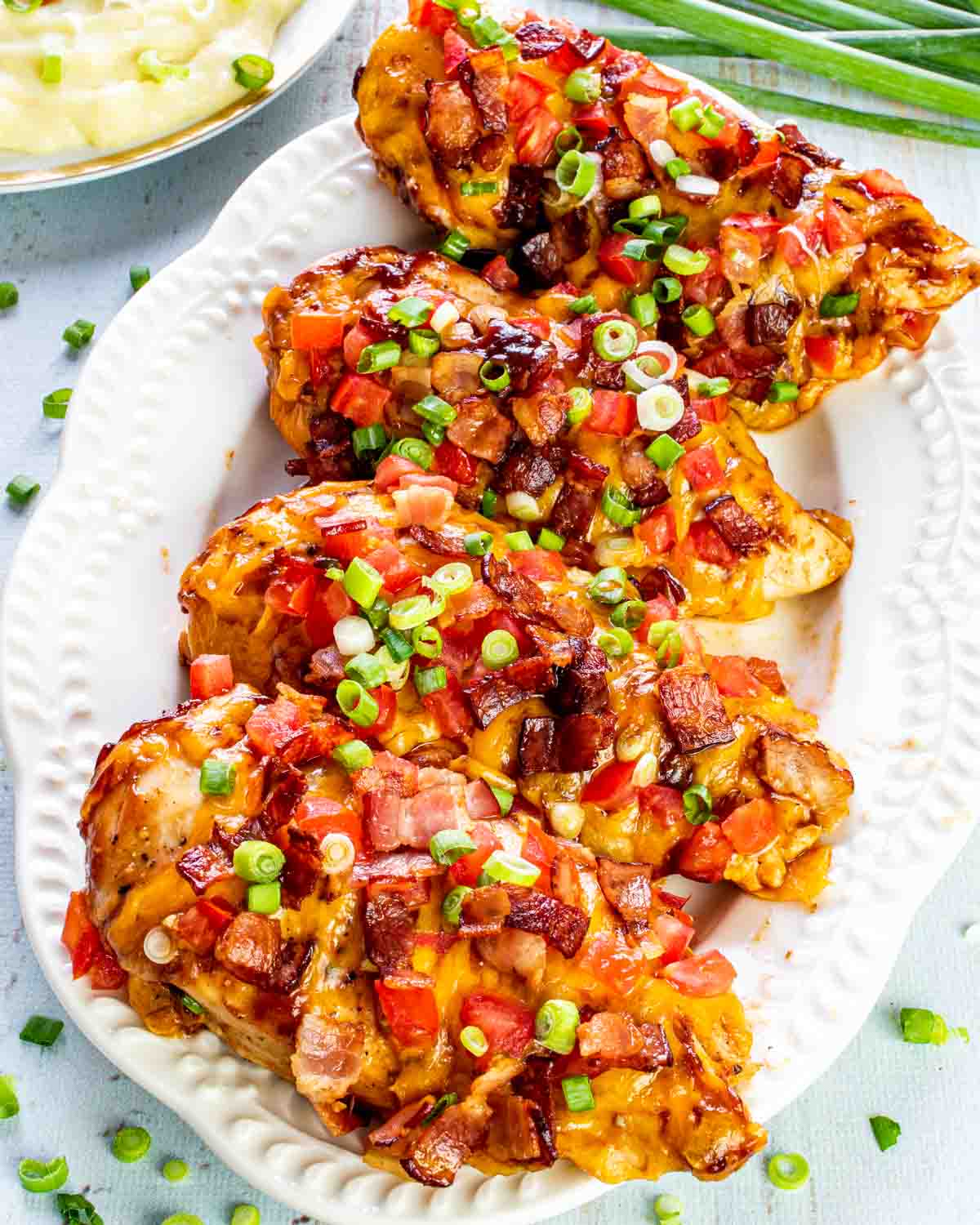 4 pieces of monterey chicken on a white platter.