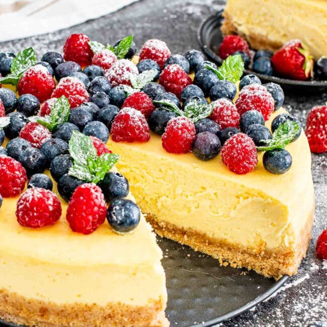 a gorgeous new york style cheesecake topped with berries.