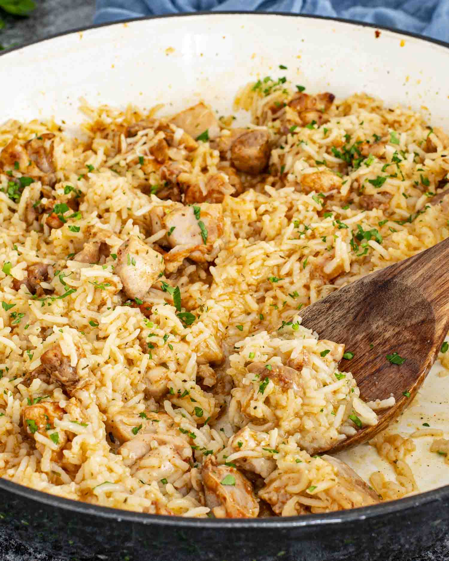 garlic butter chicken and rice in a braiser garnished with parsley.