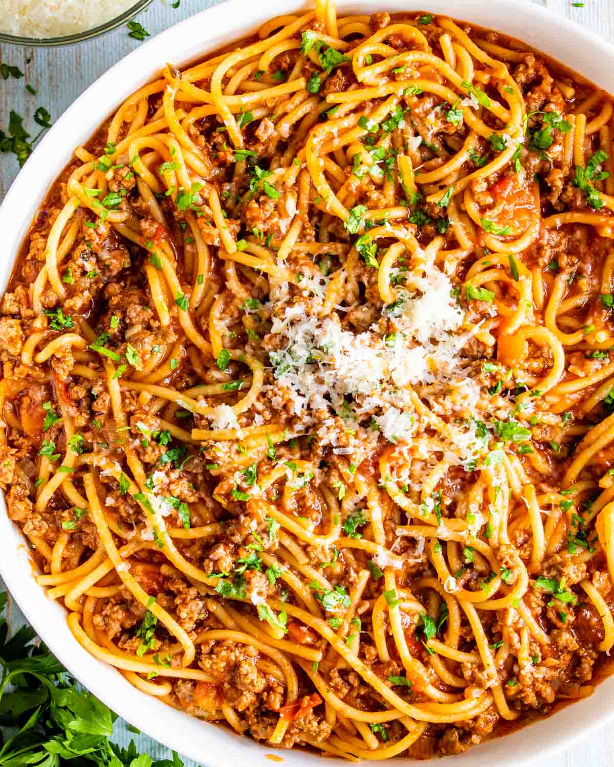 spaghetti made in one pot garnished with parmesan in a white bowl.