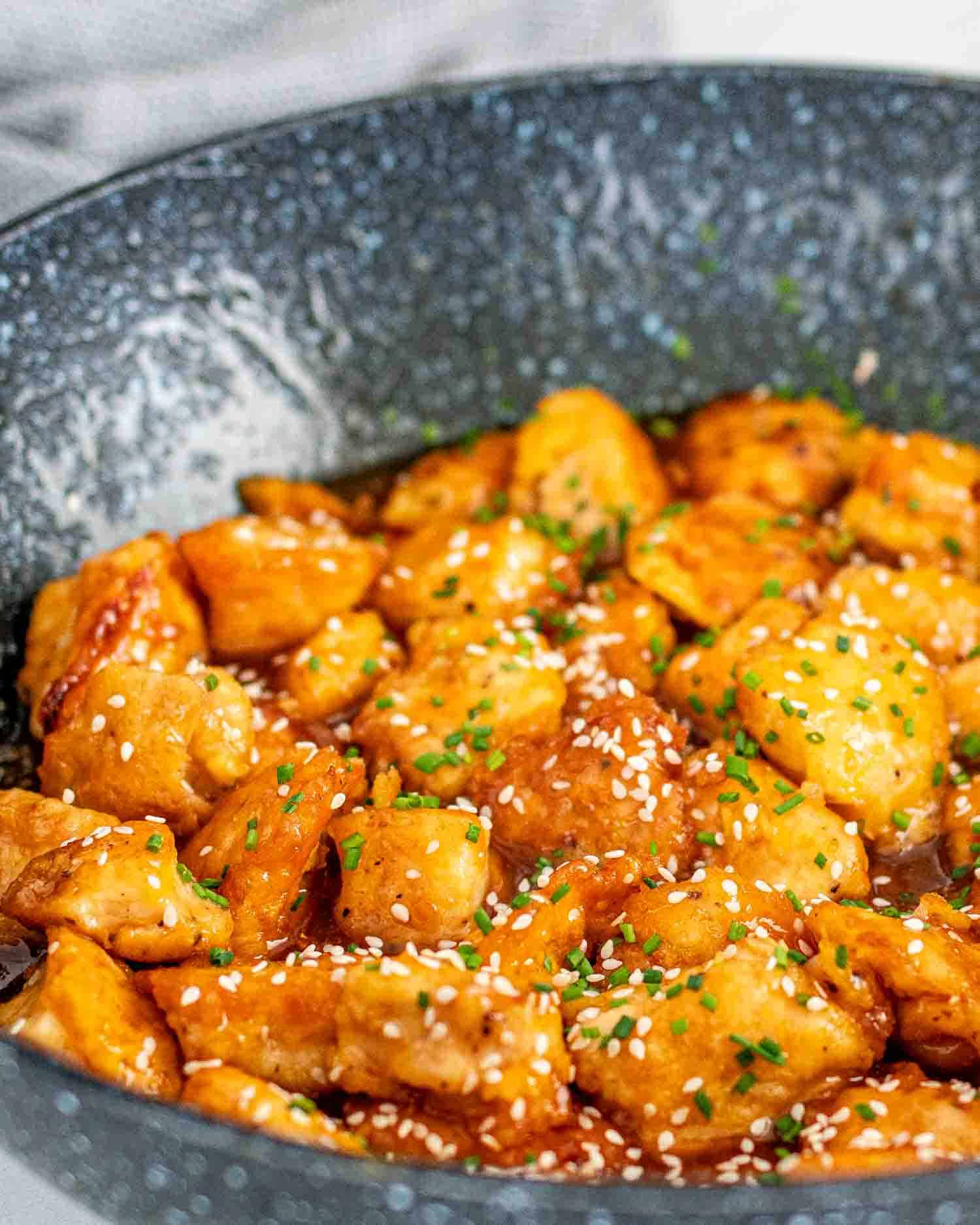 freshly made orange chicken in a wok.