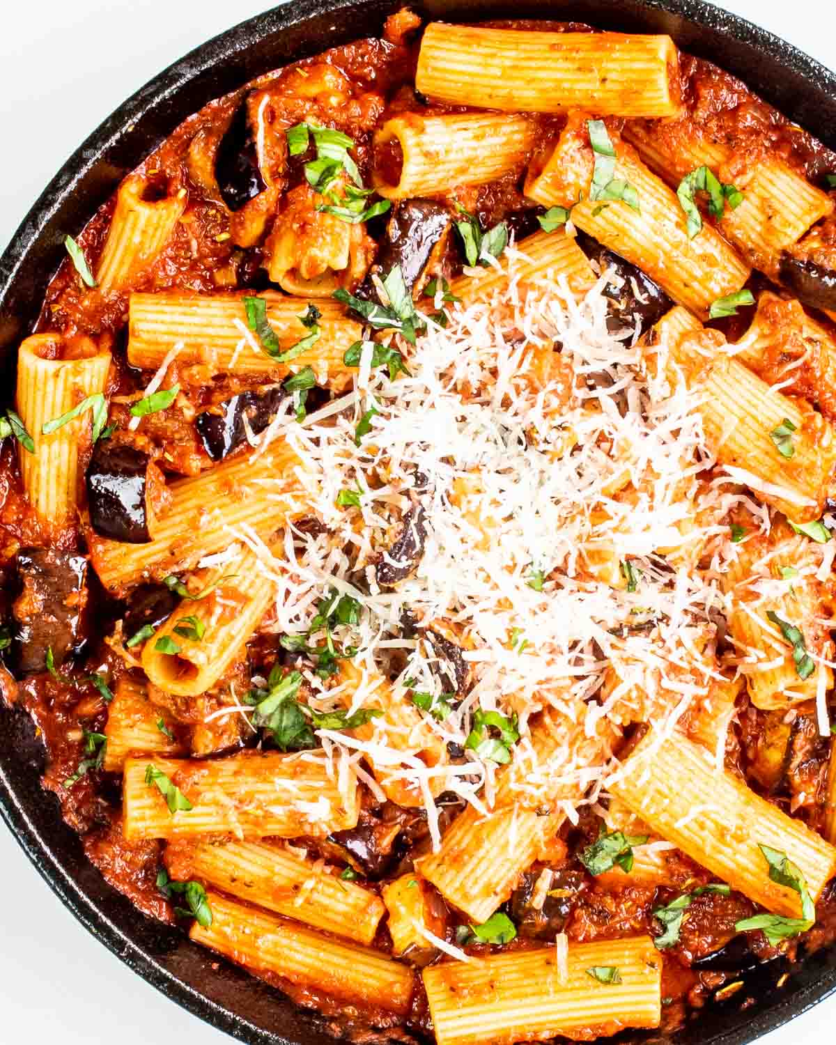 freshly made pasta alla norma in a black skillet.