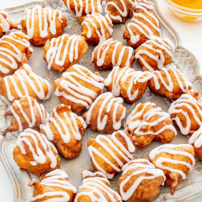 glazed peach fritters on a serving platter.