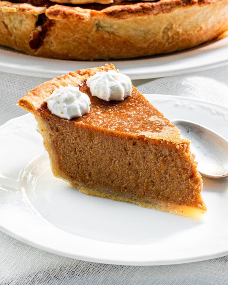 a slice of pumpkin pie on a white plate