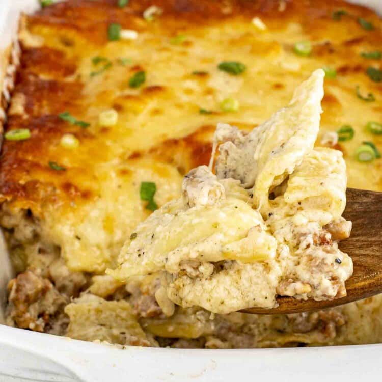 fresh out of the oven ravioli alfredo bake in a casserole dish.