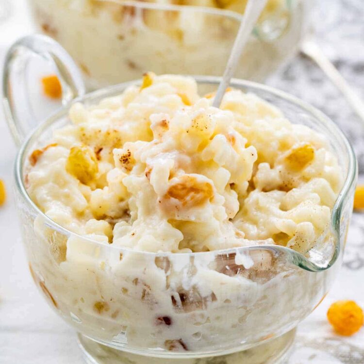 freshly made rice pudding in a glass bowl with a spoon in it