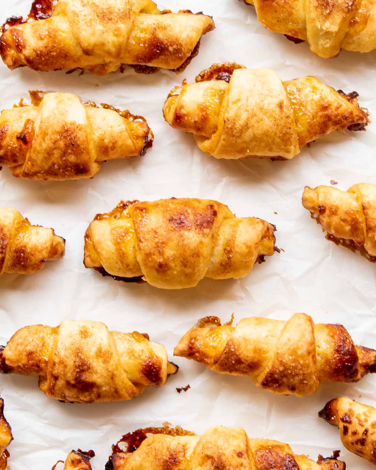 a bunch of rugelach cookies on a piece of parchment paper.