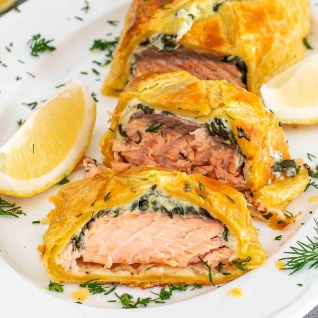 a salmon wellington sliced up on a plate.