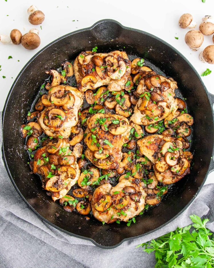 overhead shot of chicken and mushrooms in a skillet