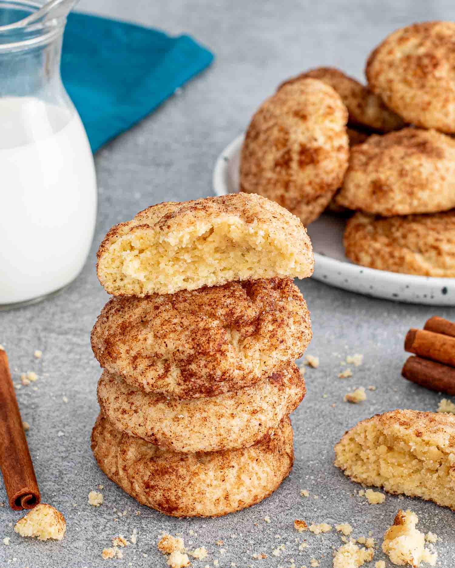 a stack of snickerdoodle cookies with a glass of milk.