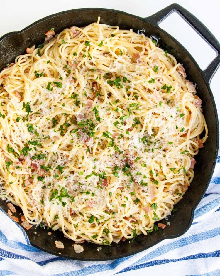 overhead shot of spaghetti carbonara in a black skillet