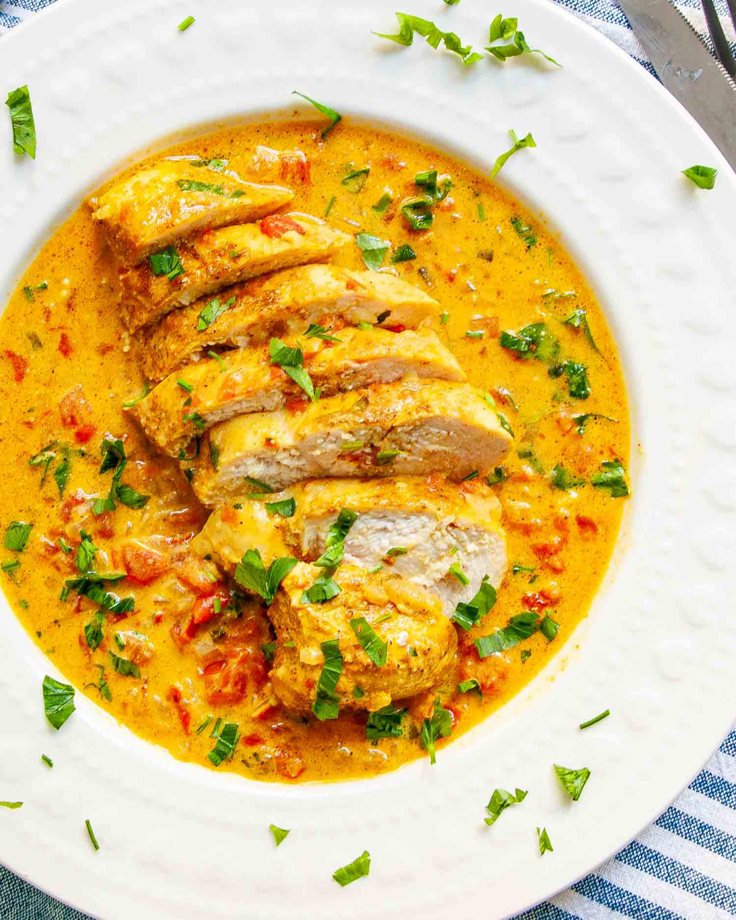 a serving of spicy brazilian coconut chicken on a white plate.