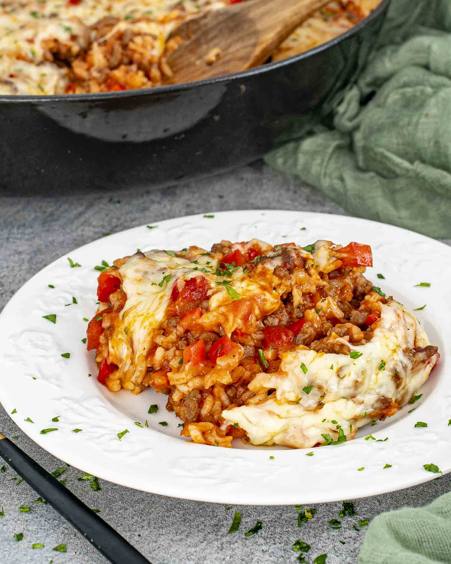 a serving of stuffed pepper casserole on a white plate garnished with a bit of parsley.