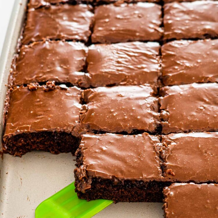 texas sheet cake in a sheet pan with icing and cut up into slices.