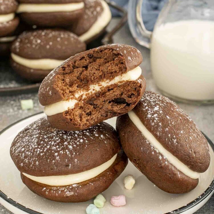 three whoopie pies on a plate with one having a bite taken out of it.