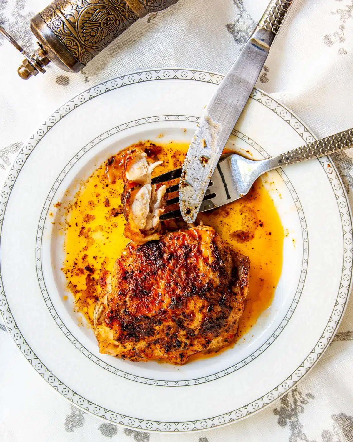 baked chicken thigh on a white plate