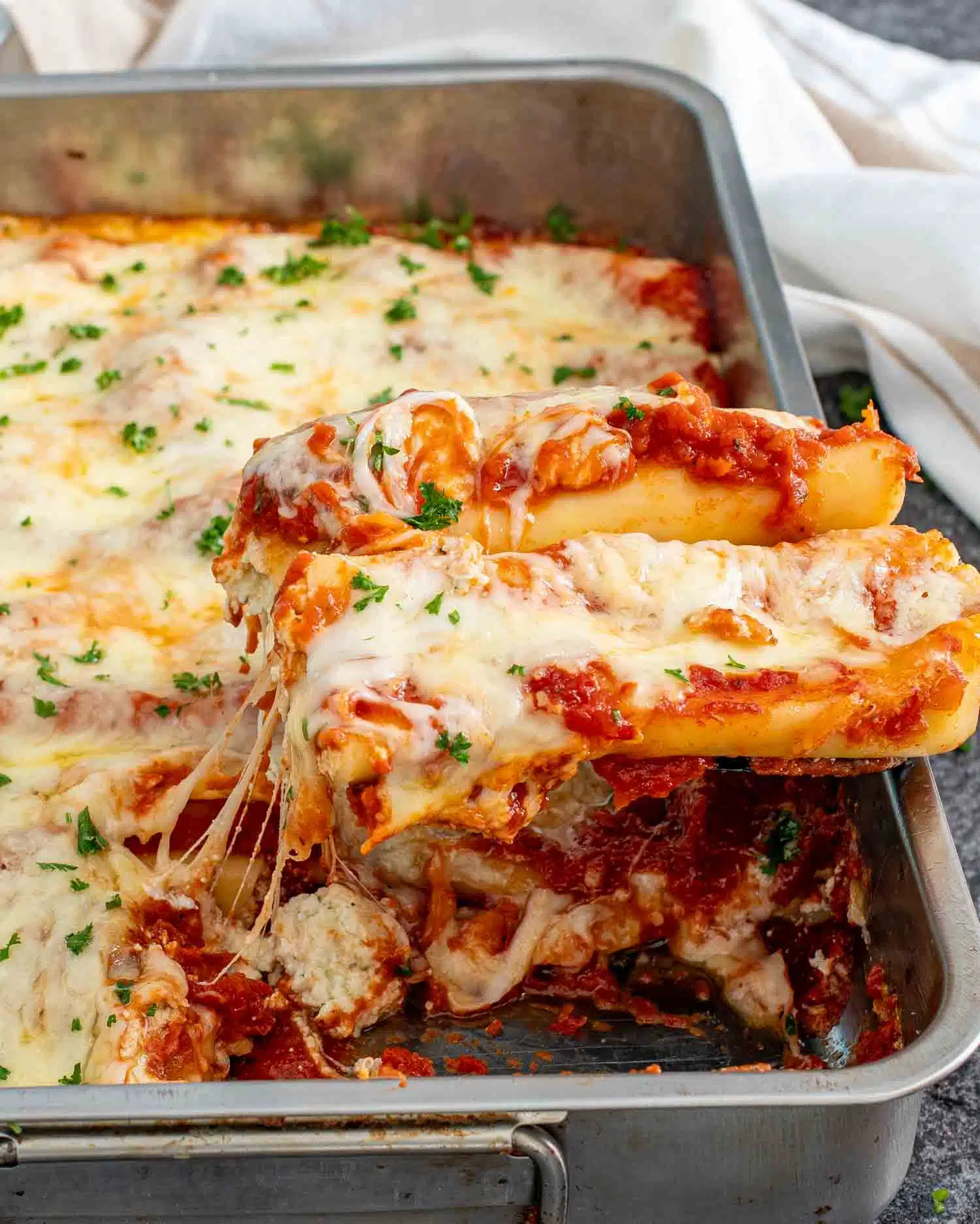freshly made cheese stuffed manicotti in a casserole dish.