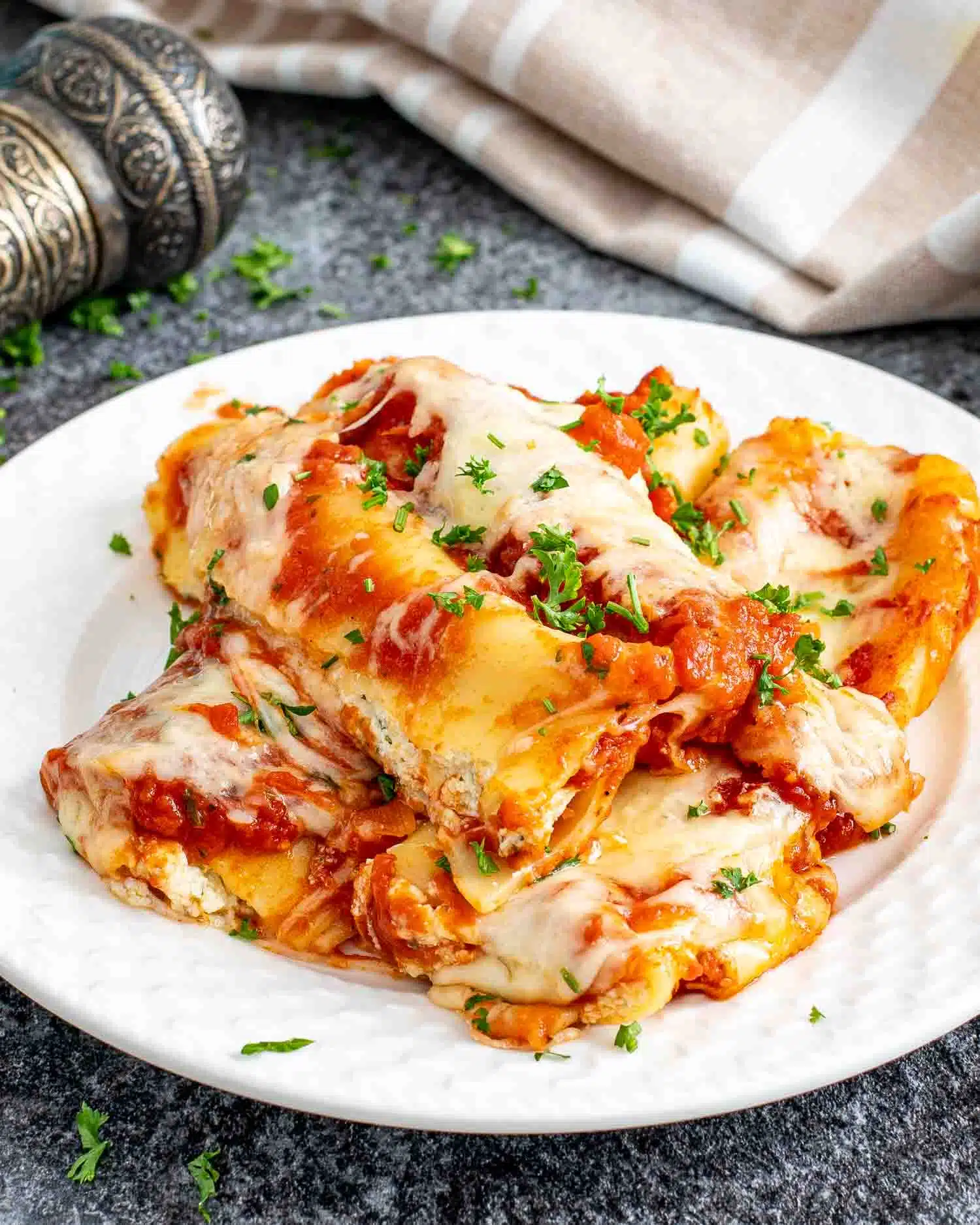 a serving of cheese stuffed manicotti on a white plate.