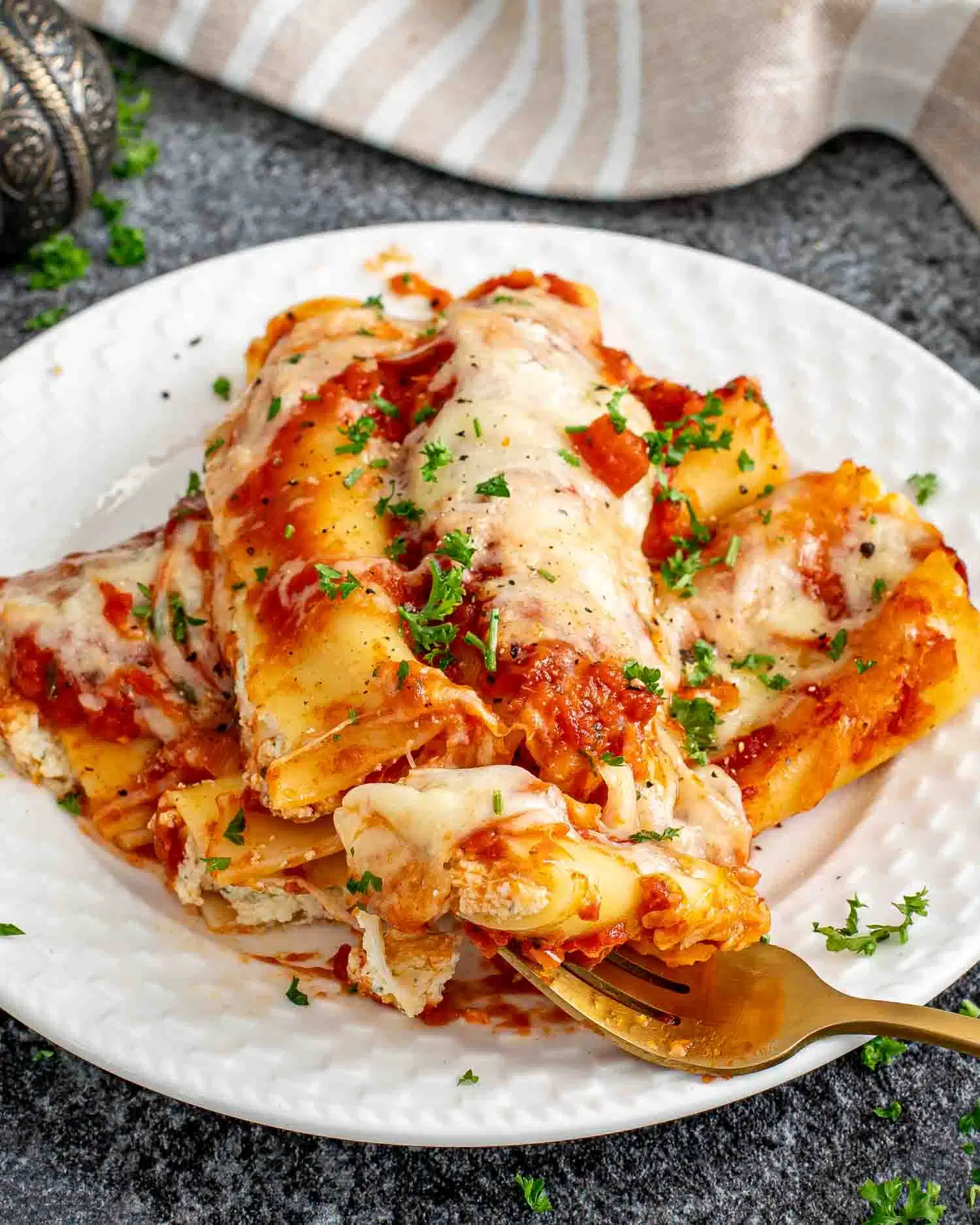 a serving of cheese stuffed manicotti on a white plate.
